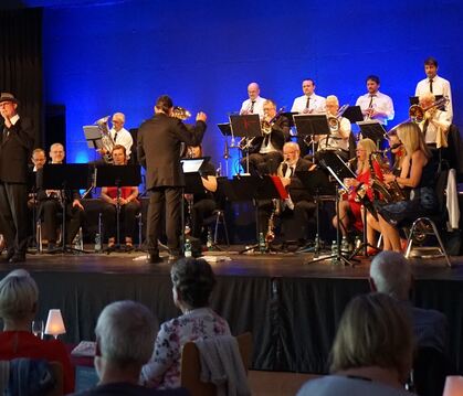 In Hochform: Sänger Klaus-Dieter Mayer (links vorne) und die Pop und Swing Concert Band beim Konzert in Gomaringen.  FOTO: STRAU