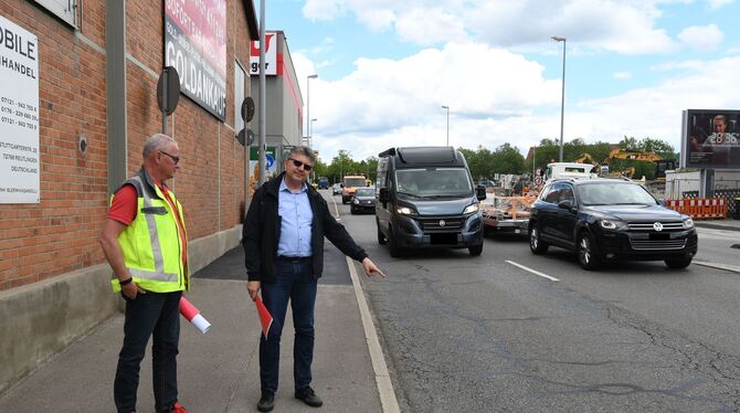 Andreas Witzemann und Bernd Eger (rechts) von der Stadt Reutlingen zeigen auf Risse in der Stuttgarter Straße. Der Belag muss dr
