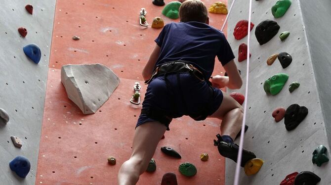 Ein Junge klettert an einer Kletterwand in Stuttgart
