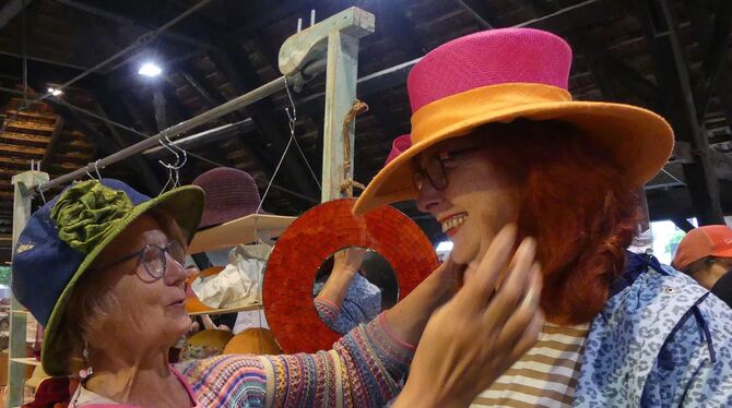 Schick, schick, die form- und farbvollendeten Hüte von Andrea Conradi (links), die hier bei einer Kundin Maß nimmt.  FOTOS: SAND