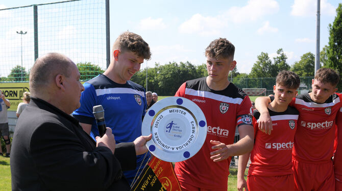 Verbandsvertreter Wolfgang Adis überreicht Torhüter Louis Potye und Jan-Christian Beifuß die Schale und den Wimpel.  FOTO: BAUR