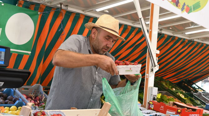 Typische Szene: Weil es die Kundin wünscht, stapelt Markthändler Frank Kuhn bereits in Pappschalen verpackte Erdbeeren noch zusä