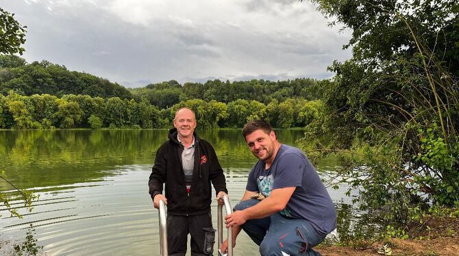 Ab ins Wasser: Roland Koch und David Bobla vom Fischereiverein Reutlingen bei der Montage der neuen Badeleitern am Baggersee.  F