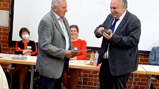 Helmut Bösch (links) wird von Dekan Michael Karwounopoulos mit der Brenz-Medaille geehrt.  FOTO: KIRCHE