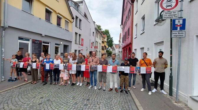 Lindenstraßenbewohner und drei SPD-Stadträte hinter einer symbolischen Absperrung aus Unterschriften und Fotos, die Parksünden d