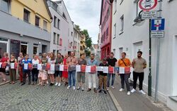 Lindenstraßenbewohner und drei SPD-Stadträte hinter einer symbolischen Absperrung aus Unterschriften und Fotos, die Parksünden d
