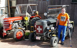 Traktor-Oldtimer-Fan und Sammler Helmut Betz mit zwei seiner zahlreichen »Schweizer Schätzchen«.  FOTO: HÄUSSLER  