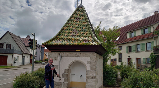 Ortsvorsteher Ulrich Kaufmann kostet den Säuerling aus dem Brunnen.  FOTO: WURSTER