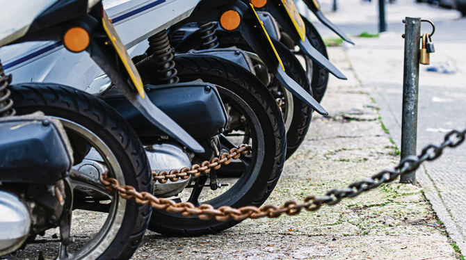 Roller stehen nebeneinander und sind durch Kettenschlösser gesichert.