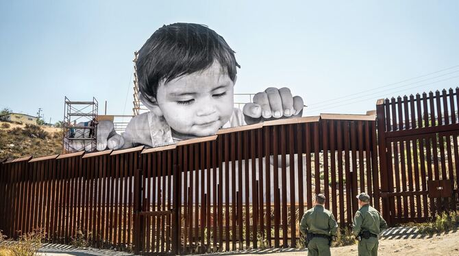 Einer von JRs »Giants«: Ein kleines Kind schaut über die Grenze von Mexiko in die USA.  FOTO: JR