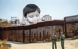 Einer von JRs »Giants«: Ein kleines Kind schaut über die Grenze von Mexiko in die USA.  FOTO: JR  