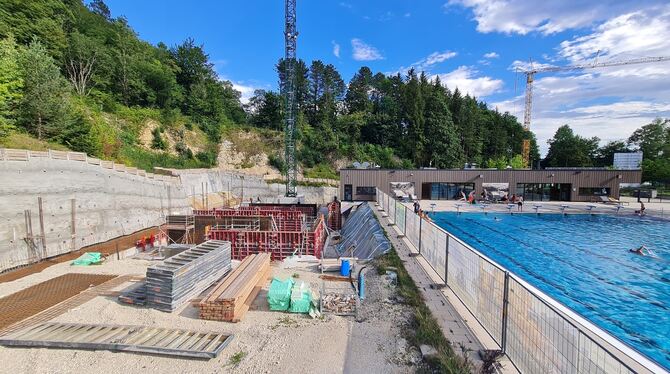 Rechts der Pool und links die Baugrube samt Hangsicherung: Direkt neben dem Freibad wird das neue Hallenbad gebaut.  FOTO: SCHRA
