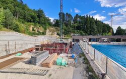 Rechts der Pool und links die Baugrube samt Hangsicherung: Direkt neben dem Freibad wird das neue Hallenbad gebaut.  FOTO: SCHRA
