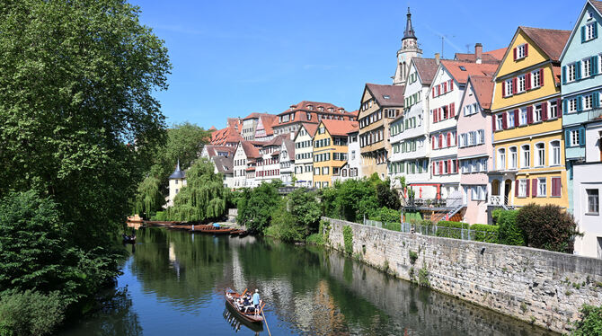 Bei strahlendem Sonnenschein fährt ein Stocherkahn auf dem Neckar in Tübingen.