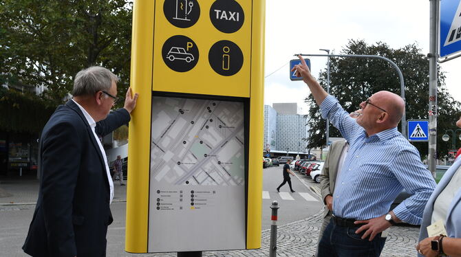 Verkehrsminister Winfried Hermann (rechts) zeigt OB Thomas Keck, was die Mobilitätssäule am Bahnhof kann.  FOTOS: ZENKE