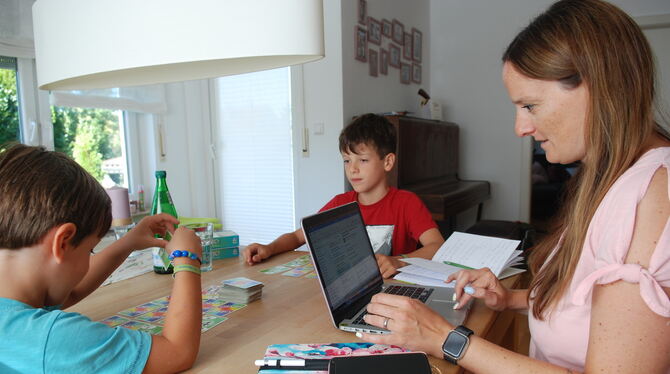 Beruf und Familie vereint: Dunja Schenk arbeitet am Laptop, ihre Kinder Moritz (5) und Felix (9) spielen in Ruhe Karten.  FOTO: