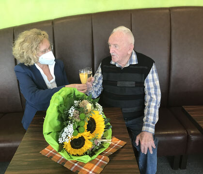Ein Gläschen auf die Gesundheit: Baubürgermeisterin Angela Weiskopf brachte Jubilar Heinz Parthum einen Blumenstrauß mit.  FOTO: