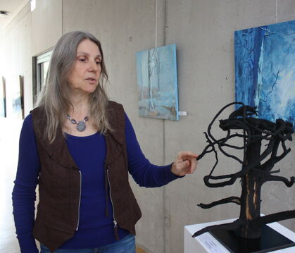 Annette Jakobi neben ihrer Skulptur »Fundstücke«: Auf einer Wurzel befestigte sie Feuerlauf-Holzkohle und einen Kronkorken. Im H