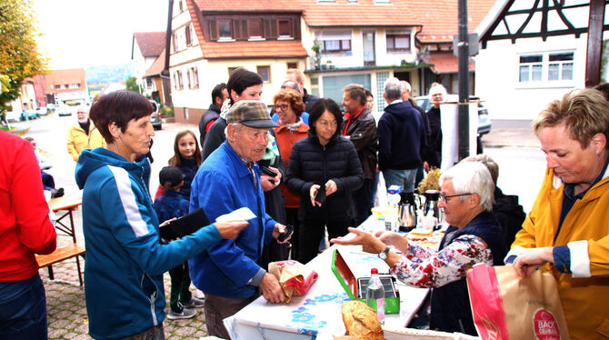 Menschen stehen in langen Schlangen an, um Brot beim »10. Herbst am Backhaus« des Gesangvereins Eintracht Lonsingen zu kaufen.