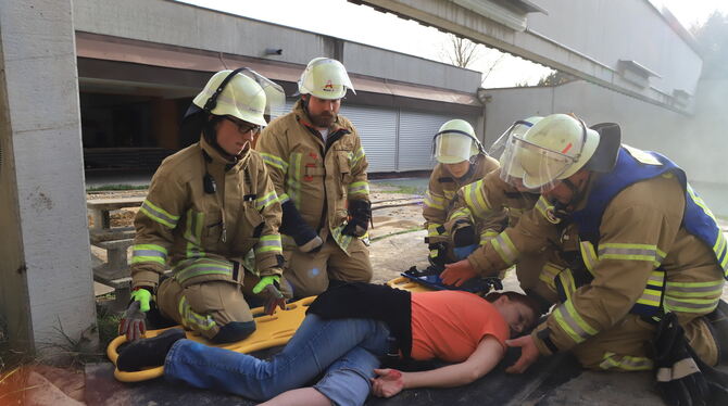 Fünf ehrenamtliche Feuerwehrangehörige kümmern sich um eine Schwerverletzte. Nach etwa einer Stunde schweißtreibendem Einsatz en