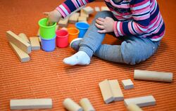 Ein Kind spielt im Kindergarten mit Bechern und Bauklätzen (Symbolbild).