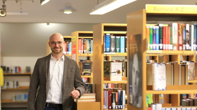 Fühlt sich pudelwohl an seinem Arbeitsplatz: Elias Huisl ist der neue Leiter der Pfullinger Bücherei.  FOTO: REISNER
