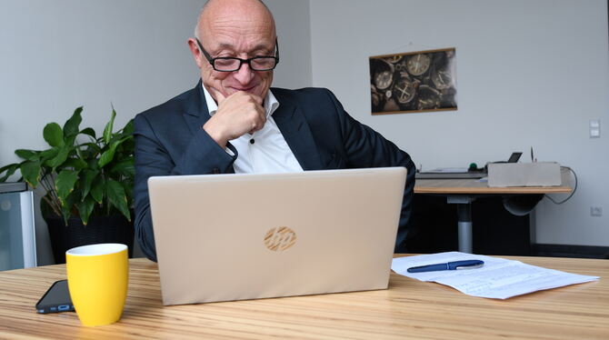 Prof. Dr. Hendrik Brumme, Präsident der Hochschule Reutlingen, schmunzelt beim Blick in den Bildschirm.  FOTO: ZENKE