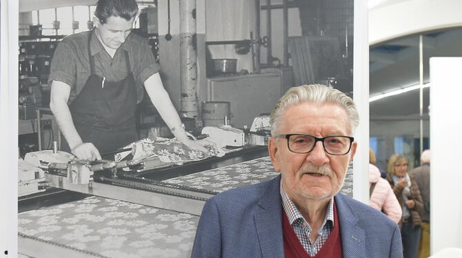 Otto Belser vor einem Plakat in einer Ausstellung, das ihn selbst als junger Stoffdrucker zeigt. Das Pausa-Urgestein ist jetzt i