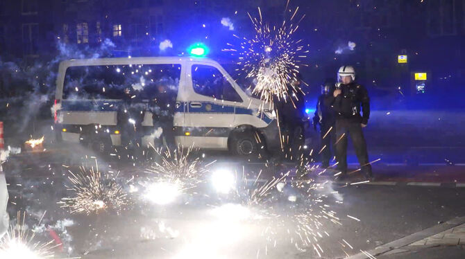 Berlin in der Silvesternacht: Polizeibeamte werden mit Feuerwerk beschossen.  FOTO: SCHREINER/DPA