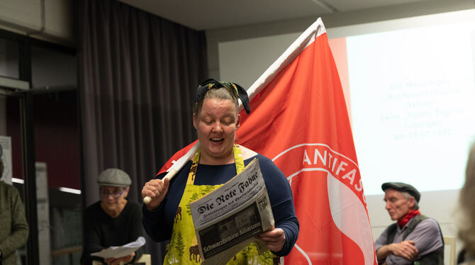 Links und rechts eine rote Fahne: Claudia Jochen zeigt die Insignien der Arbeiterbewegung. Im Hintergrund Ursel Reutter und Jürg