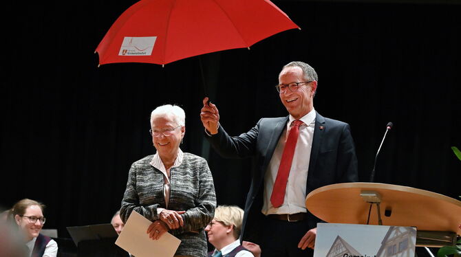 Ingeborg Schauer mit der Urkunde. Bernd Haug schenkte ihr auch noch einen der seltenen Kirchentellinsfurter Regenschirme.  FOTO: