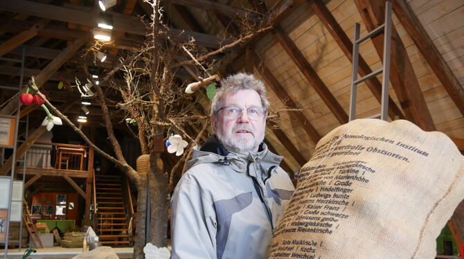Willy Müller ist der Vorsitzende des Fördervereins Obstbaumuseum Glems. Er hält einen Sack, auf dem bekannte Kirschsorten notier