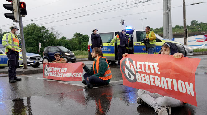 Polizisten sprechen mit Demonstranten der Aktivistengruppierung »Letzte Generation«, die eine Hauptverkehrsstraße in Stuttgart