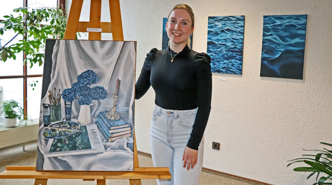 Mara Winter mit ihrem Bild »Künstler-Ästhetik-Stillleben«, das in der Ausstellung im Gomadinger Rathaus zu sehen ist.  FOTO: BLO