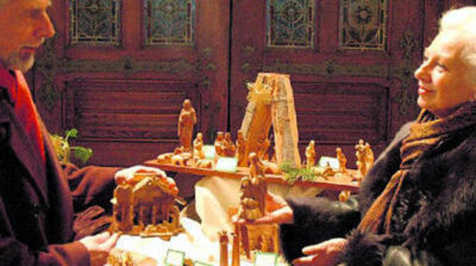 Das kräftig gemaserte Olivenholz gibt den Krippen und den schlicht, aber eindringlich geschnitzten Gestalten aus dem Ursprungsland der Weihnachtsgeschichte, aus Palästina, - hier mit Werner Petershans und Heike Gauermann - besondere Ausstrahlung.
GEA-FOTO: MEYER