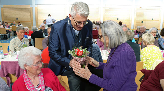 Bürgermeister Zeller begrüßte die über 90-Jährigen mit Blumenstrauß und Wein.  FOTO: BLOCHING