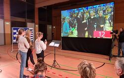 Das Orchester kam über die Leinwand zu Besuch nach Münsingen, wo zwei Rate-Teams im Musik-Quiz gegeneinander antraten.  FOTO: SC