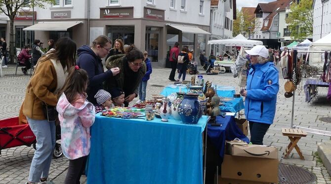 Diese Familie schaut sich das Angebot an einem Stand des Metzinger Frühjahrsmarkts auf dem Marktplatz an.  FOTO: SANDER