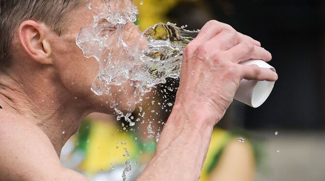 Ein Läufer schüttet sich Wasser ins Gesicht. In Tübingen dürfte es beim 100-Kilometer-Staffellauf heiß werden.