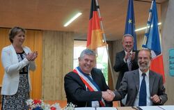  Jetzt ist es offiziell: Die Bürgermeister Laurent Favreau und Jürgen Soltau (von links) bei der Vertragsunterschrift, dahinter 
