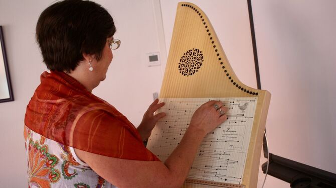 Projektleiterin Tanja Schleyerbach stimmt das Märchenlied »Der Zaunkönig« auf der Veeh-Harfe an.  FOTOS: SPIESS