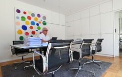 Architekt Wolfgang Riehle macht einen großen Tisch in seinem Haus vor einem Gemälde von Jerry Zeniuk zum luftigen Homeoffice. Er