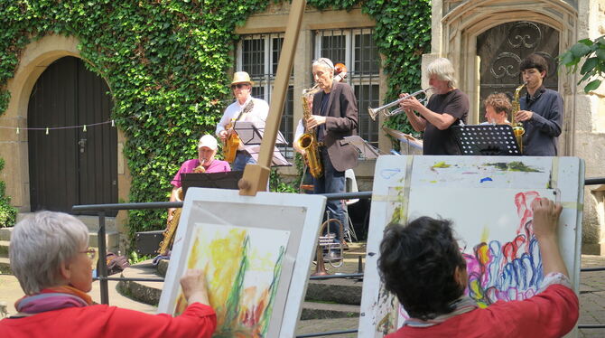 Kultur im lauschigen Garten-Ambiente: Maria Katsouli und Karin Zimmermann beim Live-Painting, im Hintergrund spielen Werner Byst