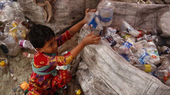 Ein Mädchen sortiert in Dhaka (Bangladesch) Plastikflaschen.  FOTO: HASAN/DPA