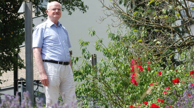 Zum Abschied rote Rosen: Pfarrer Hermann Weiß vor der Metzinger St.Bonifatiuskirche.  FOTO: PFISTERER