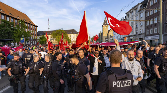 Einsatzkräfte der Polizei begleiten Anhänger des türkischen Präsidenten Erdogan im Duisburger Norden, die noch vor dem amtliche