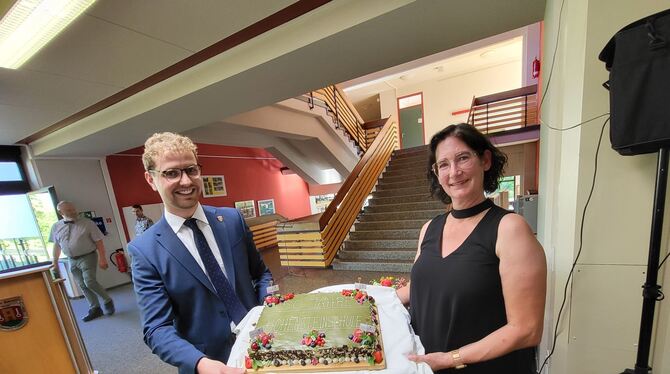 Bürgermeister Simon Baier überreichte Schulleiterin Tanja Glück eine Torte zum 50-jährigen Bestehen der Hohensteinschule.  FOTO: