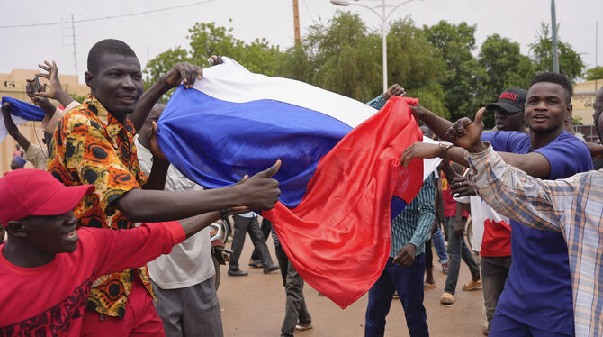 Anhänger der Putschisten im Niger schwenken während einer Demonstration die russische Flagge.