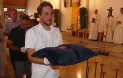 Berührender Augenblick: Der Vorsitzende des  Riederich-Teams, Valentin Bicker trägt die aus dem Altar entnommene Reliquie in die