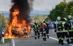 Nur mit viel Wasser und viel Zeit löschbar: Ein brennendes E-Auto auf einer Straße.